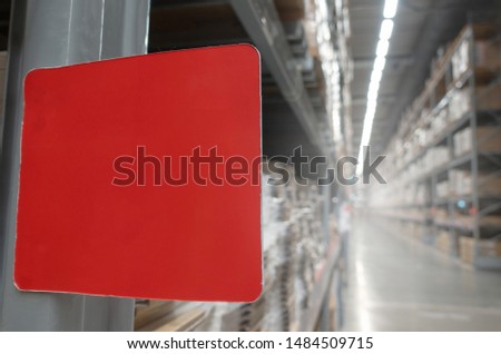 red blank price tag label on product shelves in cargo warehouse storage or supermarket interior in department store background, commercial, marketing, advertising and logistic industry concept