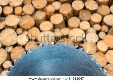 Circular saw on woodpile stack background. Wall firewood, Circular saw blade with woodpile stack of wood on background. Logging for winter process