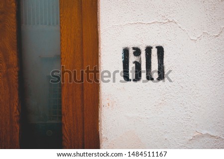 number 60 door sign sprayed at the facade