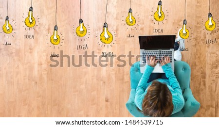 Idea light bulbs with woman using her laptop computer