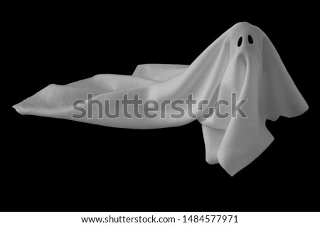 White ghost sheet costume rise up from the floor with black background. Minimal Halloween scary concept.