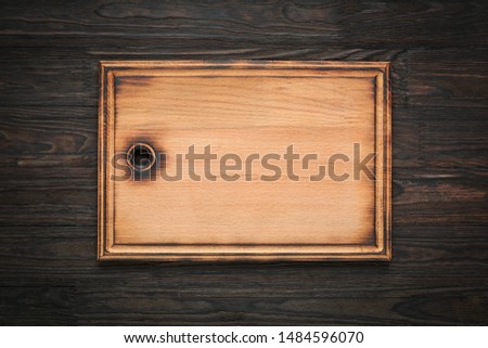 Cutting board on a wooden kitchen table, top view, copy space.