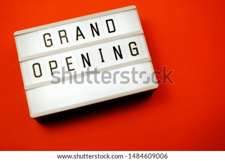 Top view Grand opening word in light box flat lay with space copy on red background
