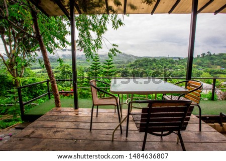 The background of the chair and counter to sit and watch the scenery, allowing tourists to stop and take public pictures while traveling, the atmosphere is surrounded by trees and mountains.