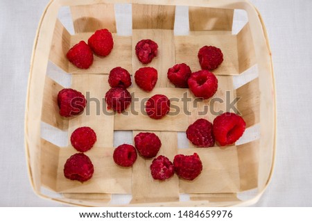 raspberries in a wooden tray, closeup.