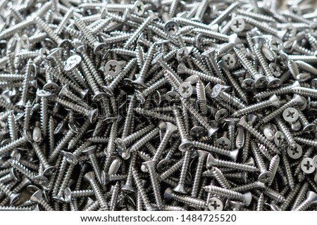 tapping screws made od steel, metal screw, iron screw, chrome screw, screws as a background, wood screw,  Royalty-Free Stock Photo #1484725520