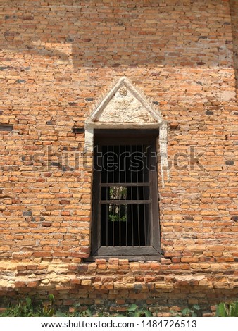 A Window on the red brick wall of Buddhist temple in Thailand 