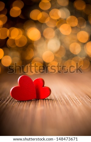Hearts on a wooden table and background is a bokeh.