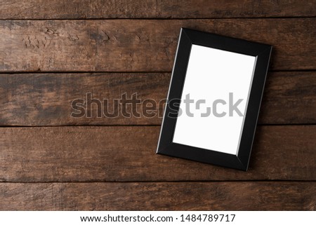 Empty photo frame mockup on wooden background