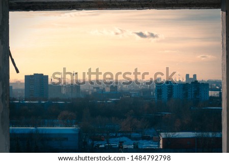 view of the city panorama in the rays of the setting sun from the window of an abandoned factory
The dark blue sky smoothly turning into a pink-yellow house in the rays of the setting sun.
