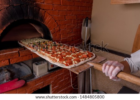 One Meter Long Pizza Directly from the Traditional Oven Served Royalty-Free Stock Photo #1484805800