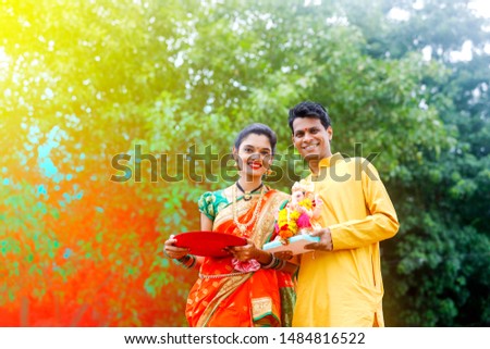 Young indian couple with lord ganesha , Indian ganesh festival