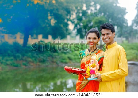 Young indian couple with lord ganesha , Indian ganesh festival