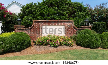 Blank sign on a brick wall at the entrance of a subdivision