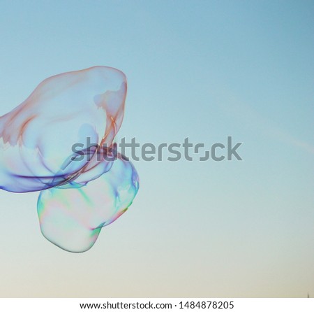 Soap bubbles on a blue sky illuminated by the sun texture background with copyspace