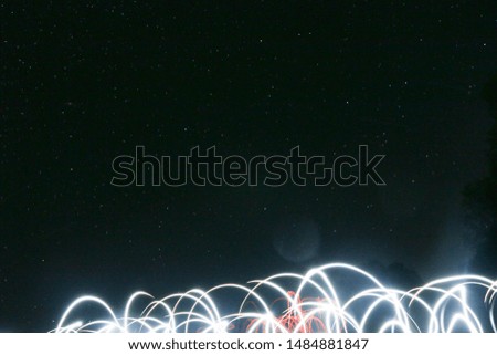 Starry sky and drawings with fire and lanterns long exposure
