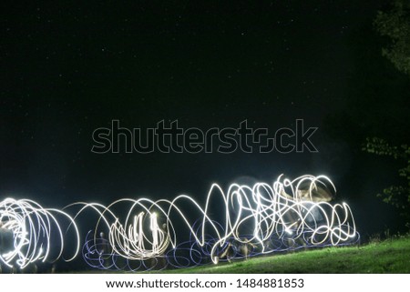 Starry sky and drawings with fire and lanterns long exposure