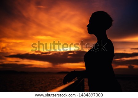 silhouette of a young girl with short hair on a sunset background