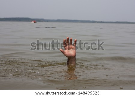 Hand of drowning man waits for help in the lake