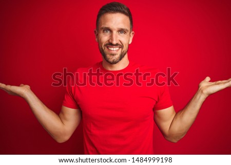 Young handsome man wearing casual t-shirt over red isolated background smiling showing both hands open palms, presenting and advertising comparison and balance