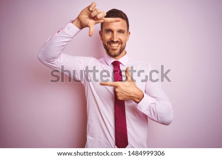Business man wearing tie and elegant shirt over pink isolated background smiling making frame with hands and fingers with happy face. Creativity and photography concept.