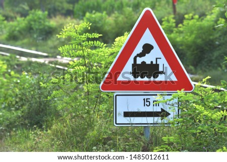Railway safety sign in nature Railroad Crossing Sign without barrier or gate ahead the road, beware of train roadside steam engine locomotive road sign on signpost pole.  15 meters until railway cross