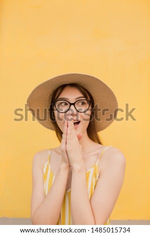 Fashion woman in stylish clothes on a background of a yellow wall. Bright photo with emotions. copy space
