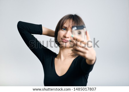 beautiful business woman taking selfie by phone isolated on gray background
