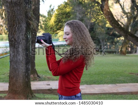 Young happy photographer in an outdoor park.