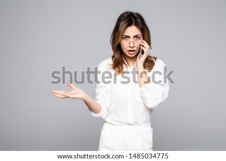 Portrait of a smiling young casual brunette woman talking on mobile phone isolated over white background