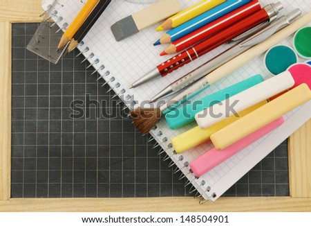 School supplies on notepad on school board 