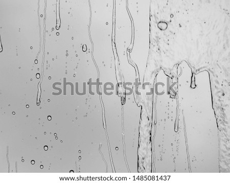The raindrops and drips on a glass .