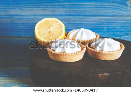 White aircake with lemon filling and lemon on a wooden table