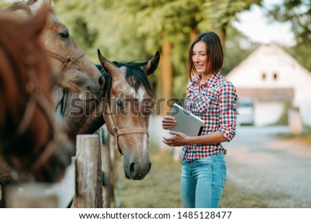Young woman farmer on a horse farm