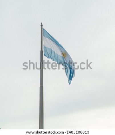 Argentina flag blowing in the wind, with sky background. Blue and white flag with golden sun. Shot in Buenos Aires.