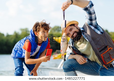 Son feeling surprised. Son feeling surprised and excited while seeing fish caught by father