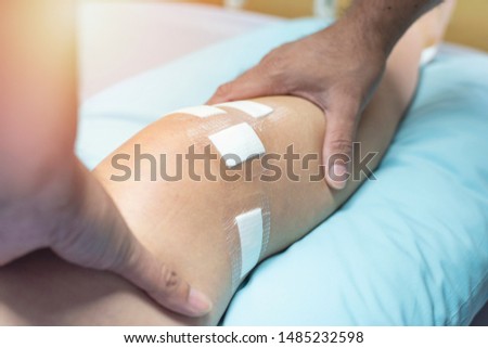Hand of doctor touch on leg of patient after do ligament surgery on bed in hospital,healthcare and medical concept.  Royalty-Free Stock Photo #1485232598