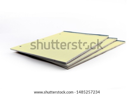 pads of yellow three hole punched legal note paper isolated on white
