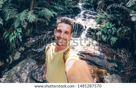 Happy young man take a selfie on a excursion in the forest at summer - Beatiful guy taking a self portrait with his smartphone
