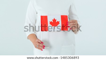 Close-up of the flag of Canada in female hands. Woman is Canadian.