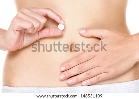 Birth control pill, Contraceptive pills, Vitamin pill, pills for better digestion or pills against menstrual pain. Woman holding white tablet in front of stomach. Close up. Royalty-Free Stock Photo #148531109