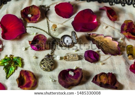 A pocket watches and rose petals on the table