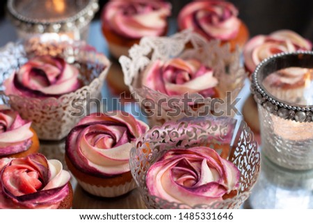 A beautiful, colorful stock image with cupcakes on a cake stand with decorations of flowers and candles
