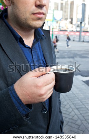 cup of a coffee in the mans hand  on the open air