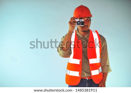 Worker taking a photo over on soft blue background.