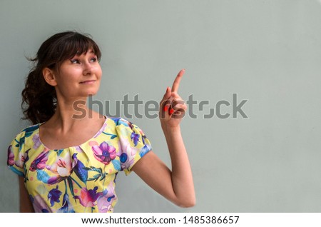 Beautiful girl pointing to the side. Copy space for text or product. Presenting your product. Isolated on background. Advertisement