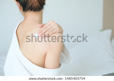 The woman is applying cream,lotion on her back., Hygiene skin body care concept. Royalty-Free Stock Photo #1485403754