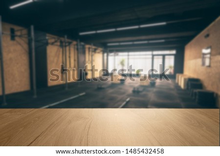 Wooden surface with unfocused crossfit room in the background, gym table.
