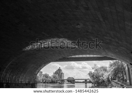 Water under a bridge looking out at a city skyline