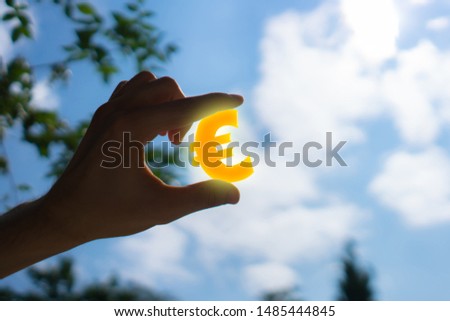 hand holding a euro sign, money increase symbol concept, financial freedom
